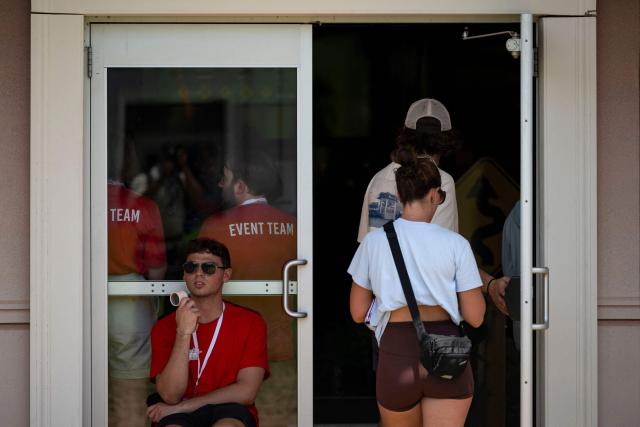 An event team member sits pointing a handheld fan to his face as people visit the "Great American State Fair" on the National Mall in Washington, DC, on July 2, 2026, ahead of the upcoming July 4 holiday. Americans sweltered under furnace-like temperatures this week as central and eastern cities hunkered down for a heat wave set to last through the July 4 holiday weekend. Dozens of local temperature records could be broken, the National Weather Service (NWS) warned, with temperatures in many places to surpass 100 degrees Fahrenheit (38 degrees Celsius) and high humidity pushing the heat index as high as 115 degrees. (Photo by Kent Nishimura / AFP)