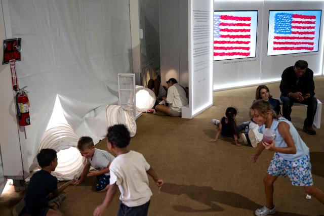 People sit in front of vents pumping cool air into a tent as they visit the "Great American State Fair" on the National Mall in Washington, DC, on July 2, 2026, ahead of the upcoming July 4 holiday. Americans sweltered under furnace-like temperatures this week as central and eastern cities hunkered down for a heat wave set to last through the July 4 holiday weekend. Dozens of local temperature records could be broken, the National Weather Service (NWS) warned, with temperatures in many places to surpass 100 degrees Fahrenheit (38 degrees Celsius) and high humidity pushing the heat index as high as 115 degrees. (Photo by Kent Nishimura / AFP)