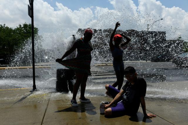 People cool off with water from an open fire hydrant during a heat wave on the West Side of Chicago, Illinois, on July 2, 2026. Blistering temperatures and humidity gripped swaths of the United States on July 1, with the worst yet to come for the densely populated East Coast as the nation co-hosts the World Cup and prepares to celebrate its 250th birthday. "Heat dome" conditions -- in which high-pressure systems trap warm air like the lid on a pot -- persisted over the Midwest and South and were moving east, with some 46 million people under heat alerts. (Photo by OCTAVIO JONES / AFP)