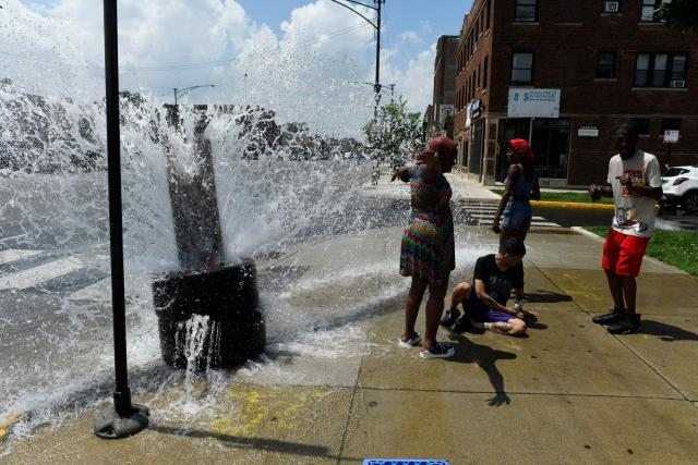 People cool off with water from an open fire hydrant during a heat wave on the West Side of Chicago, Illinois, on July 2, 2026. Blistering temperatures and humidity gripped swaths of the United States on July 1, with the worst yet to come for the densely populated East Coast as the nation co-hosts the World Cup and prepares to celebrate its 250th birthday. "Heat dome" conditions -- in which high-pressure systems trap warm air like the lid on a pot -- persisted over the Midwest and South and were moving east, with some 46 million people under heat alerts. (Photo by OCTAVIO JONES / AFP)