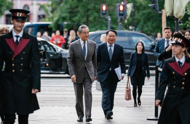 China's Foreign Minister Wang Yi (C-L) arrives for a visit of Tivoli Gardens Amusement Park in Copenhagen on July 2, 2026. The Chinese Foreign Minister visits Denmark on July 2 and 3, 2026. He will furthermore visit Sweden, Finland, and Norway. (Photo by Emil Nicolai Helms / Ritzau Scanpix / AFP) / Denmark OUT