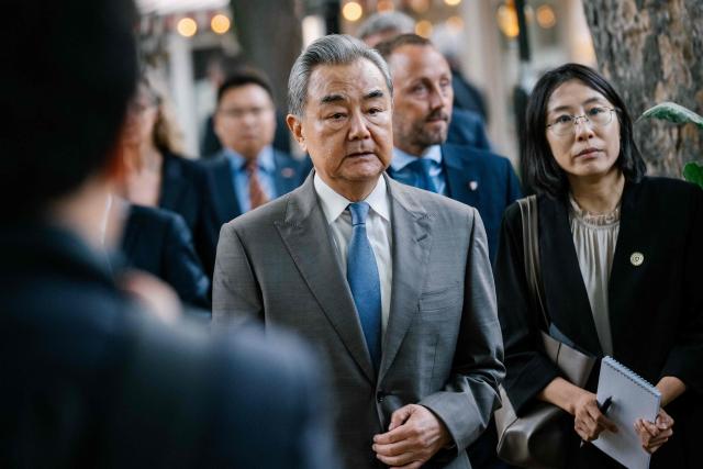 China's Foreign Minister Wang Yi (C) visits Tivoli Gardens Amusement Park in Copenhagen on July 2, 2026. The Chinese Foreign Minister visits Denmark on July 2 and 3, 2026. He will furthermore visit Sweden, Finland, and Norway. (Photo by Emil Nicolai Helms / Ritzau Scanpix / AFP) / Denmark OUT