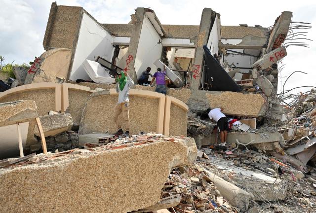 Locals attempt to recover belongings at the site of a collapsed building in Caraballeda, La Guaira state, Venezuela, on July 2, 2026, eight days after twin earthquakes. Hundreds of rescuers in Venezuela cheered and embraced on July 2, 2026 after pulling 43-year-old Hernan Gil from the ruins of a collapsed building eight days after deadly twin earthquakes, AFP journalists witnessed. (Photo by MARTIN BERNETTI / AFP)