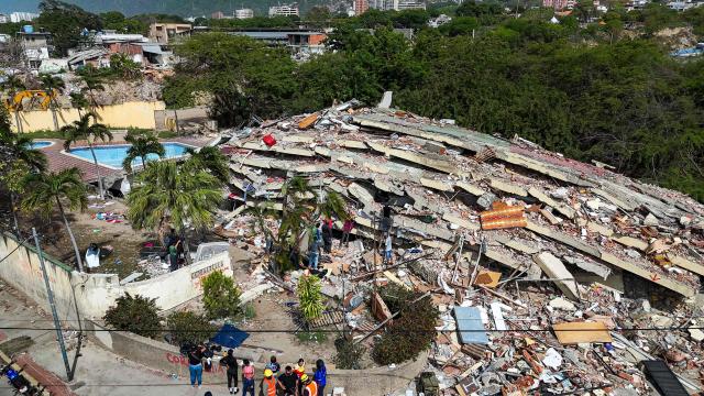 This aerial photograph taken on July 2, 2026 in Caraballeda in the state of La Guaira shows damaged buildings following the June 24 twin earthquakes. More than a week after the earthquakes struck, there is little chance of finding additional survivors from the two earthquakes that killed nearly 2,300 people, destroyed entire residential buildings, and left tens of thousands missing. (Photo by Miguel MEDINA / POOL / AFP)