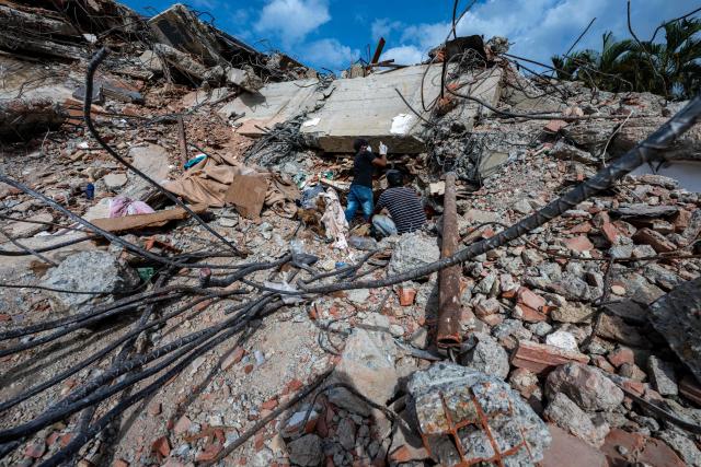 This photograph taken on July 2, 2026 in Caraballeda in the state of La Guaira shows volunteers looking for survivors in a collapsed building following the June 24 twin earthquakes. More than a week after the earthquakes struck, there is little chance of finding additional survivors from the two earthquakes that killed nearly 2,300 people, destroyed entire residential buildings, and left tens of thousands missing. (Photo by Miguel MEDINA / POOL / AFP)