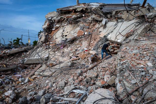 This photograph taken on July 2, 2026 in Caraballeda in the state of La Guaira shows volunteers looking for survivors in a collapsed building following the June 24 twin earthquakes. More than a week after the earthquakes struck, there is little chance of finding additional survivors from the two earthquakes that killed nearly 2,300 people, destroyed entire residential buildings, and left tens of thousands missing. (Photo by Miguel MEDINA / POOL / AFP)