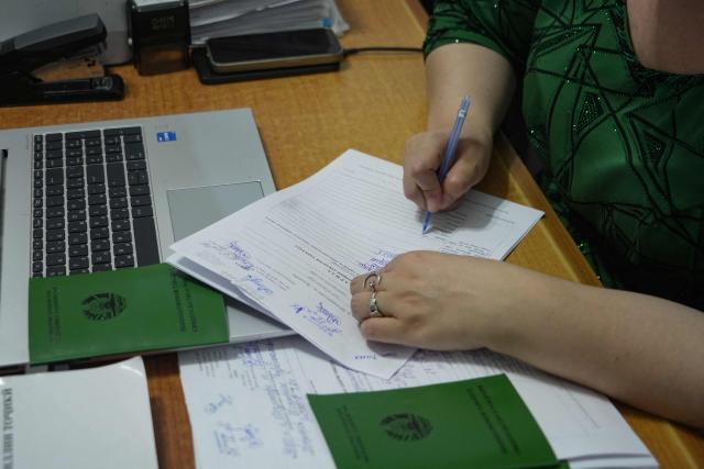 An employee of a civil registry office prepares a baby's birth certificate before hanging it to a mother in the Tajik capital of Dushanbe on June 30, 2026. (Photo by AFP)