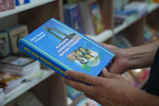 A man holds a book of Tajik names at a bookstore in the Tajik capital of Dushanbe on June 30, 2026. (Photo by AFP)