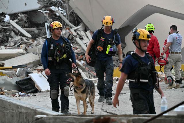 US rescuers withdraw from the area after failing to find any survivors during search operations in Caraballeda, La Guaira state, Venezuela, on July 2, 2026, eight days after twin earthquakes. Hundreds of rescuers in Venezuela cheered and embraced on July 2, 2026 after pulling 43-year-old Hernan Gil from the ruins of a collapsed building eight days after deadly twin earthquakes, AFP journalists witnessed. (Photo by MARTIN BERNETTI / AFP)