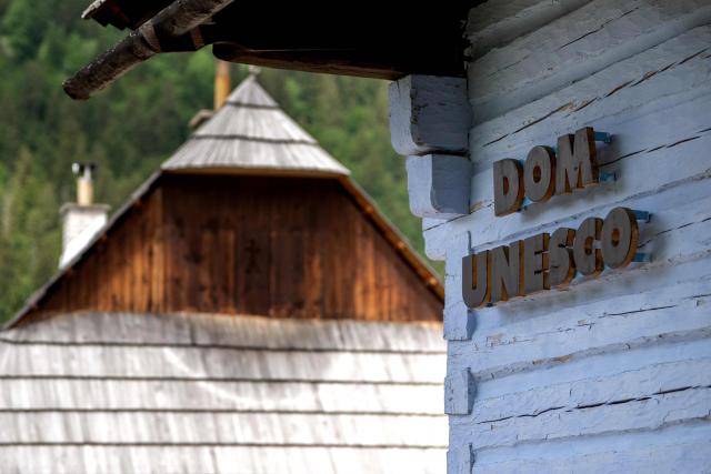 The 'UNESCO House' is seen next to traditional log houses at the UNESCO-listed Slovak village of Vlkolinec, near the Central Slovakian town of Ruzomberok on June 6, 2026. The village Vlkolinec was recognized by UNESCO in 1993 and with 45 original houses is one of the three preserved groups of wooden houses in Central Europe on the World Heritage list, along with two other sites located in Hungary and the Czech Republic. (Photo by Joe KLAMAR / AFP)
