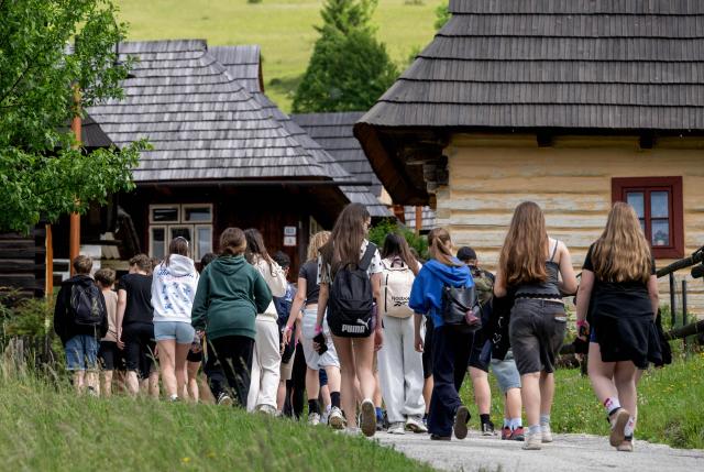 A group of students arrive at the UNESCO-listed Slovak village of Vlkolinec, near the Central Slovakian town of Ruzomberok on June 6,2026. The village Vlkolinec was recognized by UNESCO in 1993 and with 45 original houses is one of the three preserved groups of wooden houses in Central Europe on the World Heritage list, along with two other sites located in Hungary and the Czech Republic. (Photo by Joe KLAMAR / AFP)