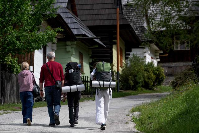 Tourists walk past log houses at the UNESCO-listed Slovak village of Vlkolinec, near the Central Slovakian town of Ruzomberok on June 6,2026. The village Vlkolinec was recognized by UNESCO in 1993 and with 45 original houses is one of the three preserved groups of wooden houses in Central Europe on the World Heritage list, along with two other sites located in Hungary and the Czech Republic. (Photo by Joe KLAMAR / AFP)