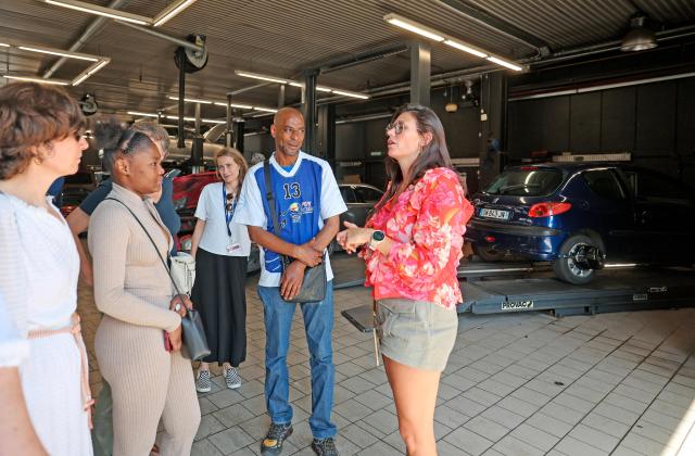 Norauto HR managers explain garage operations to former inmates during a "Day at Norauto" event, organized by M6 Foundation, in Villeneuve-d'Ascq on June 24, 2026. The scene takes place at Norauto, where six former inmates took part in a day-long event organized in late June by the M6 Foundation, which works to help people under judicial supervision reintegrate into society. For participating companies, these events also help address recruitment challenges in certain fields. (Photo by Francois LO PRESTI / AFP)