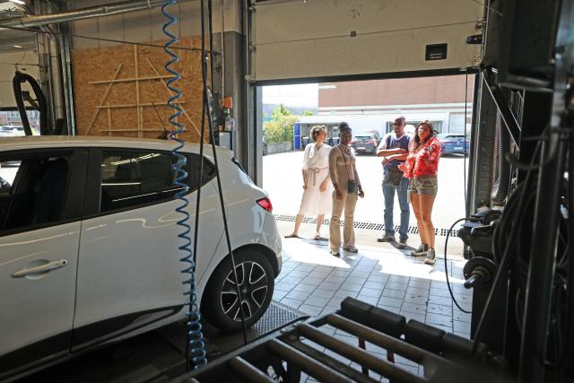 Norauto HR managers explain garage operations to former inmates during a "Day at Norauto" event, organized by M6 Foundation, in Villeneuve-d'Ascq on June 24, 2026. The scene takes place at Norauto, where six former inmates took part in a day-long event organized in late June by the M6 Foundation, which works to help people under judicial supervision reintegrate into society. For participating companies, these events also help address recruitment challenges in certain fields. (Photo by Francois LO PRESTI / AFP)