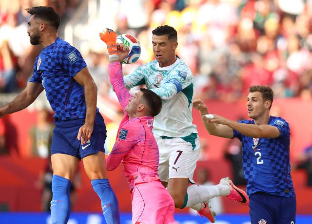Croatia's goalkeeper #01 Dominik Livakovic clears the ball next to Portugal's forward #07 Cristiano Ronaldo during the 2026 World Cup round of 32 football match between Portugal and Croatia at the Toronto Stadium in Toronto on July 2, 2026.  (Photo by Cole Burston / AFP)
