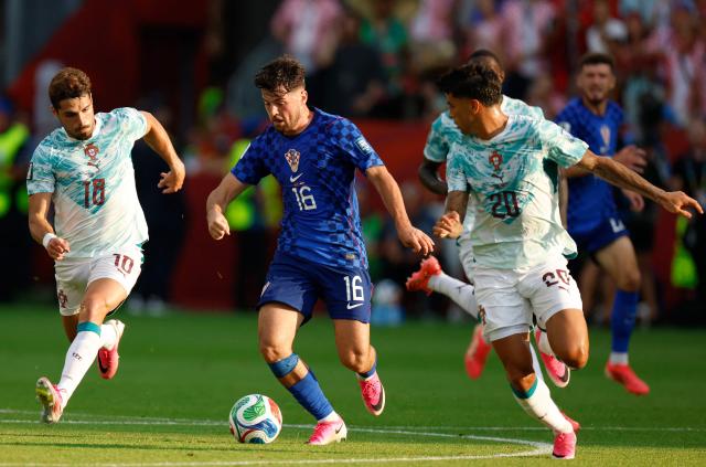 Portugal's forward #18 Pedro Neto, defender #20 Joao Cancelo and Croatia's midfielder #16 Martin Baturina fight for the ball during the 2026 World Cup round of 32 football match between Portugal and Croatia at the Toronto Stadium in Toronto on July 2, 2026.  (Photo by Kamil Krzaczynski / AFP)