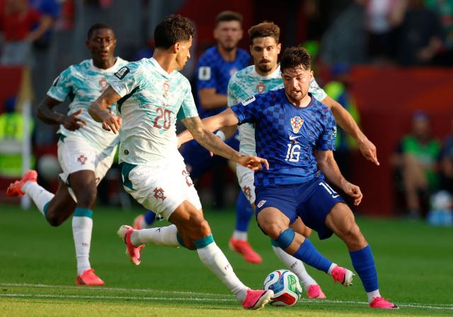 Portugal's defender #20 Joao Cancelo and Croatia's midfielder #16 Martin Baturina fight for the ball during the 2026 World Cup round of 32 football match between Portugal and Croatia at the Toronto Stadium in Toronto on July 2, 2026.  (Photo by Kamil Krzaczynski / AFP)