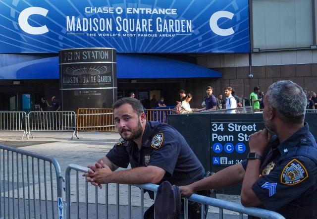 New York City police officers stand guard outside Madison Square Garden in Manhattan, New York on July 2, 2026. Increasing signs point to a mega-bash for the A-list celebrity couple Taylor Swift and Travis Kelce at Madison Square Garden kicking off on July 2, 2026 with a rehearsal dinner. Rumors have run rampant for weeks that the 36-year-old pop superstar and the three-time NFL Super Bowl winner, also 36, could wed at the storied sports arena, home to the New York Knicks, the newly crowned NBA champions. (Photo by Ryan MURPHY / AFP)