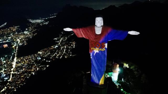 This aerial view shows the Christ the Redeemer monument illuminated in the colors of the Venezuelan flag and displaying the message "SOS Venezuela" in solidarity with the victims of the deadly twin earthquakes that struck on June 24, in Rio de Janeiro, Brazil, on July 2, 2026. (Photo by Jose Osorio / AFP)