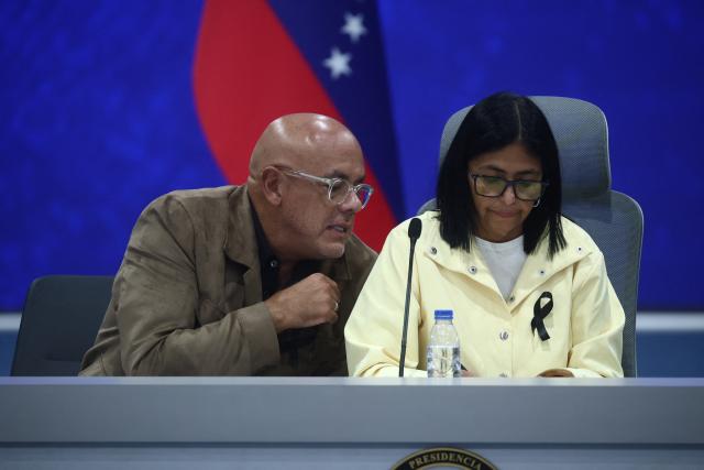 Venezuela's interim President Delcy Rodriguez (R) gives a press conference alongside National Assembly President Jorge Rodriguez and Interior Minister Diosdado Cabello (out of frame) at the Generalisimo Francisco de Miranda Air Base in Caracas on July 2, 2026. At least 2,595 people have died as a result of the twin earthquakes that struck Venezuela on June 24, interim President Delcy Rodriguez announced on July 2, adding that all of the victims will be properly identified. (Photo by Lucas AGUAYO / AFP)