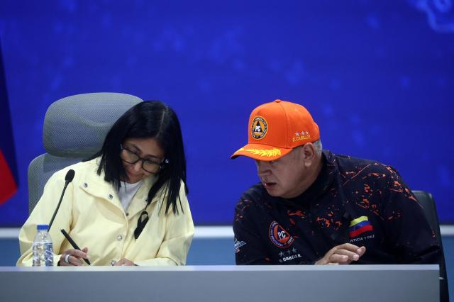 Venezuela's interim President Delcy Rodriguez (L) gives a press conference alongside Interior Minister Diosdado Cabello and National Assembly President Jorge Rodriguez (out of frame) at the Generalisimo Francisco de Miranda Air Base in Caracas on July 2, 2026. At least 2,595 people have died as a result of the twin earthquakes that struck Venezuela on June 24, interim President Delcy Rodriguez announced on July 2, adding that all of the victims will be properly identified. (Photo by Lucas AGUAYO / AFP)
