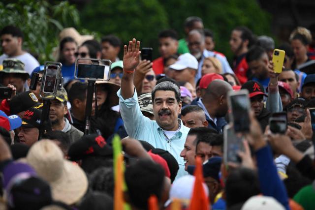 (FILES) Venezuela's President Nicolas Maduro (C) greets supporters upon his arrival at a rally marking the anniversary of the Battle of Santa Ines, in Caracas on December 10, 2025. July 3, 2026 marks six months since the capture of Nicolas Maduro during a US military operation in Venezuela. (Photo by Federico PARRA / AFP)