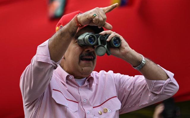 (FILES) Venezuela's President Nicolas Maduro looks through binoculars during a rally in Caracas on December 1, 2025. July 3, 2026 marks six months since the capture of Nicolas Maduro during a US military operation in Venezuela. (Photo by Juan BARRETO / AFP)