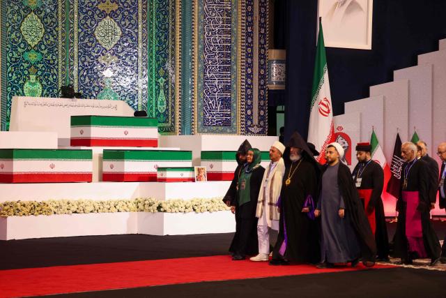TOPSHOT - Local and foreign officials walk past the coffins of Iran's slain supreme leader Ali Khamenei and his family members after paying their respects at the Grand Mosalla in Tehran on July 3, 2026. The body of Iran's supreme leader Ali Khamenei, who was killed in US-Israeli strikes, arrived at Tehran's Grand Mosalla religious complex ahead of his funeral, state media reported on July 3. (Photo by Atta KENARE / AFP) / 