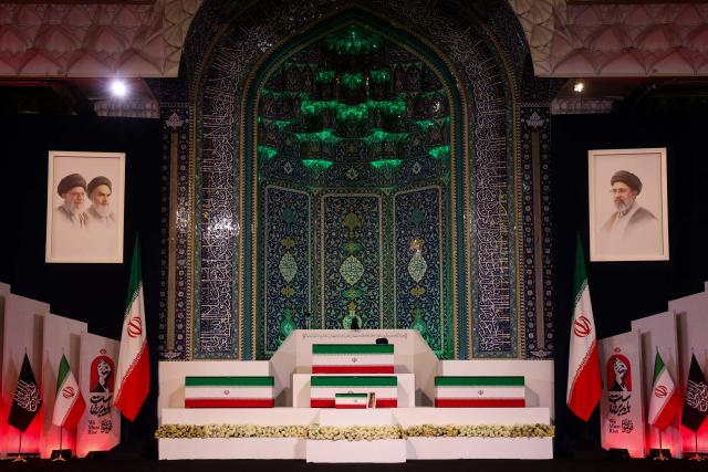 TOPSHOT - The coffins of Iran's slain supreme leader Ali Khamenei and his family members are pictured at the Grand Mosalla in Tehran on July 3, 2026. The body of Iran's supreme leader Ali Khamenei, who was killed in US-Israeli strikes, arrived at Tehran's Grand Mosalla religious complex ahead of his funeral, state media reported on July 3. The body of Iran's supreme leader who was killed in US-Israeli strikes that triggered the Middle East war arrived at Tehran's Grand Mosalla on Friday ahead of his funeral, state media reported. Millions of people and a coterie of foreign dignitaries were expected to attend July 4 official ceremony for Ali Khamenei, with Tehran's chief negotiator calling for a massive turnout to avenge his death. (Photo by Atta KENARE / AFP) / 