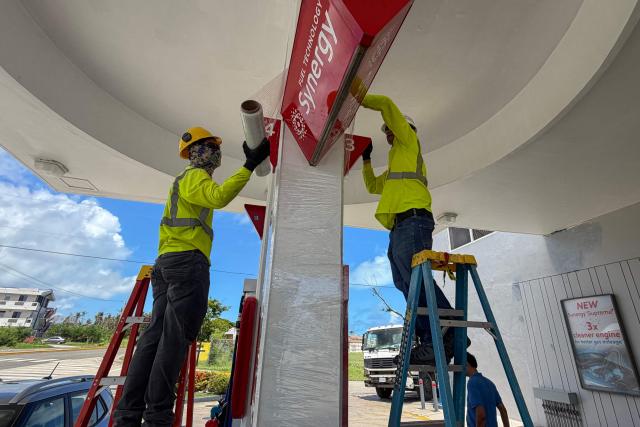 Workers secure a gas station ahead of the arrival of the forecasted Super Typhoon Bavi in Saipan, Northern Mariana Islands, on July 3, 2026. (Photo by Mark RABAGO / AFP)
