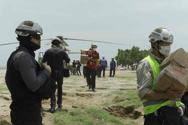 Rescue workers unload supplies from a Venezuelan Air Force helicopter in La Guaira on July 2, 2026. More than a week after the earthquakes struck, there is little chance of finding additional survivors from the two earthquakes that killed nearly 2,500 people, destroyed entire residential buildings, and left tens of thousands missing. (Photo by Rosali Hernandez / AFP)