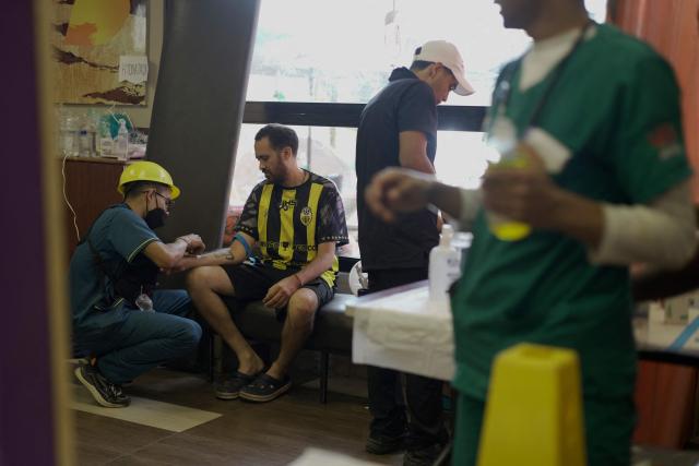 People receive medical attention in a McDonald's restaurant that was turned into a shelter and makeshift hospital to assist earthquake victims, in Caraballeda, La Guaira, on July 1, 2026. More than a week after the earthquakes struck, there is little chance of finding additional survivors from the two earthquakes that killed nearly 2,500 people, destroyed entire residential buildings, and left tens of thousands missing. (Photo by Rosali Hernandez / AFP)
