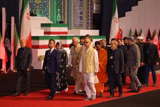 Members of Indian delegation walk past the coffins of Iran's slain supreme leader Ali Khamenei and his family members after paying their respects at the Grand Mosalla in Tehran on July 3, 2026. The body of Iran's supreme leader Ali Khamenei, who was killed in US-Israeli strikes, arrived at Tehran's Grand Mosalla religious complex ahead of his funeral, state media reported on July 3. (Photo by Atta KENARE / AFP) / 