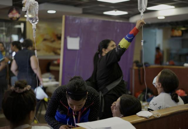 People receive medical attention in a McDonald's restaurant that was turned into a shelter and makeshift hospital to assist earthquake victims, in Caraballeda, La Guaira, on July 1, 2026. More than a week after the earthquakes struck, there is little chance of finding additional survivors from the two earthquakes that killed nearly 2,500 people, destroyed entire residential buildings, and left tens of thousands missing. (Photo by Rosali Hernandez / AFP)