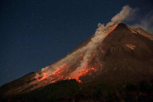 Lava and pyroclastic flows erupt from the summit of Mount Merapi during an eruption, as seen from Ngori Hamlet, Central Java, on July 3, 2026. (Photo by DEVI RAHMAN / AFP)
