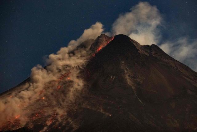 Lava and pyroclastic flows erupt from the summit of Mount Merapi during an eruption, as seen from Ngori Hamlet, Central Java, on July 3, 2026. (Photo by DEVI RAHMAN / AFP)