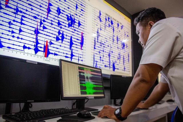 An official monitors the volcanic activity of Mount Merapi on a large LCD screen at the office of the Geological Disaster Technology Research and Development Center (BPPTKG) in Yogyakarta on July 2, 2026. BPPTKG is the Indonesian government agency responsible for 24-hour monitoring, research and hazard mitigation of Mount Merapi. (Photo by DEVI RAHMAN / AFP)