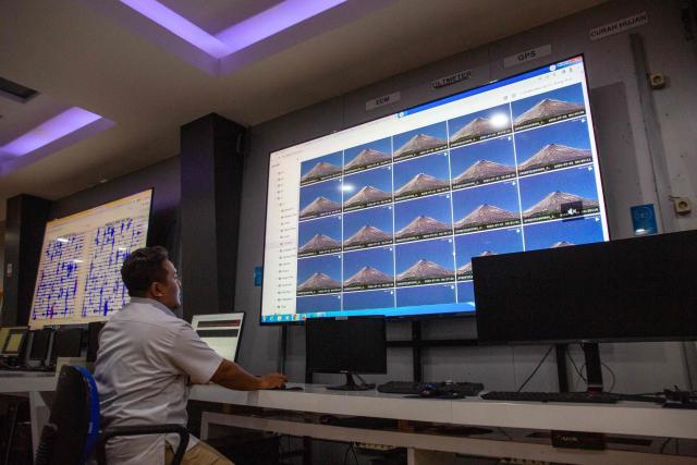 An official monitors the volcanic activity of Mount Merapi on a large LCD screen at the office of the Geological Disaster Technology Research and Development Center (BPPTKG) in Yogyakarta on July 2, 2026. BPPTKG is the Indonesian government agency responsible for 24-hour monitoring, research and hazard mitigation of Mount Merapi. (Photo by DEVI RAHMAN / AFP)