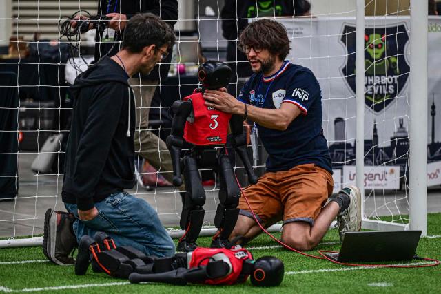 Participants prepare their robots for a football match at RoboCup 2026, a robotics and Artificial Intelligence (AI) competition in Incheon on July 3, 2026. (Photo by Jade GAO / AFP)