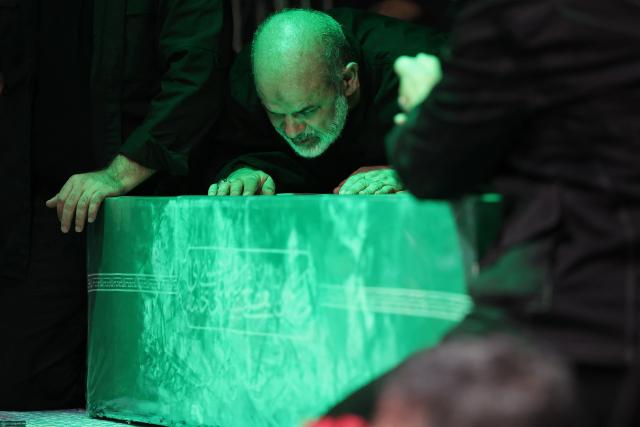 This handout photograph provided by the Iranian supreme leader office (Khamenei.IR) shows the chief of Iran's Revolutionary Guards, Ahmad Vahidi (C) paying respect at the coffin of Iran's slain supreme leader Ali Khamenei during a ceremony ahead of his funeral in Tehran on July 3, 2026. Vahidi paid his respects in Tehran before the body of Ali Khamenei, his first public appearance since the start of the Middle East war, footage broadcast on July 3 by Iranian media showed. (Photo by KHAMENEI.IR / AFP) / 