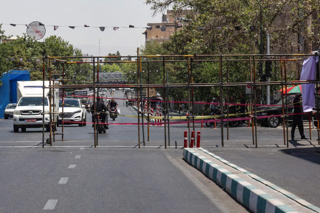 Motorists drive past temporary metal scaffoldings installed as street barriers ahead of Iran's slain supreme leader Ali Khamenei's funeral in Tehran on July 3, 2026. The body of Iran's supreme leader, killed in US-Israeli strikes that triggered the Middle East war, arrived at Tehran's Grand Mosalla on July 3 ahead of his funeral, state media reported. Millions of people and a coterie of foreign dignitaries were expected to attend Saturday's official ceremony for Ali Khamenei, with Tehran's chief negotiator calling for a massive turnout to avenge his death. (Photo by AFP) / 