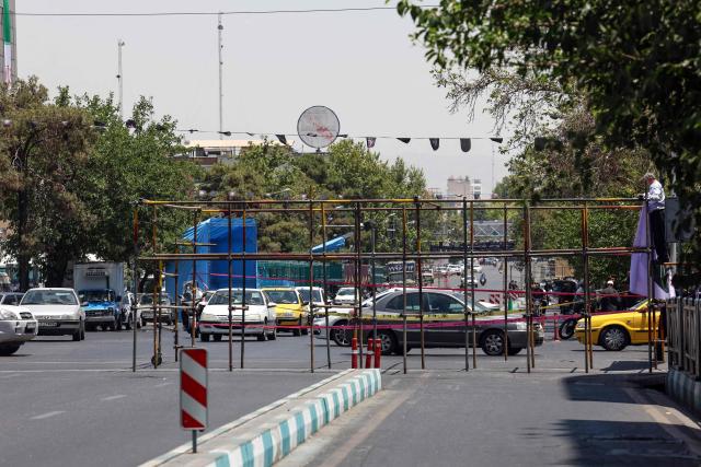 Motorists drive past temporary metal scaffoldings installed as street barriers ahead of Iran's slain supreme leader Ali Khamenei's funeral in Tehran on July 3, 2026. The body of Iran's supreme leader, killed in US-Israeli strikes that triggered the Middle East war, arrived at Tehran's Grand Mosalla on July 3 ahead of his funeral, state media reported. Millions of people and a coterie of foreign dignitaries were expected to attend Saturday's official ceremony for Ali Khamenei, with Tehran's chief negotiator calling for a massive turnout to avenge his death. (Photo by AFP) / 