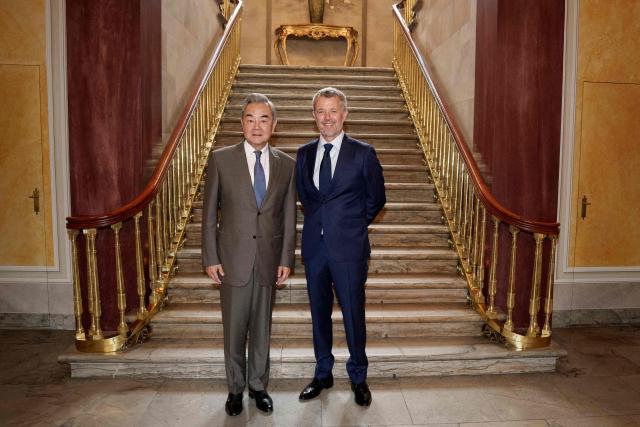 China's Foreign Minister Wang Yi (L) poses with King Frederik X of Denmark at Amalienborg Palace in Copenhagen, on July 3, 2026. The Chinese Foreign Minister is on a two day visit to Denmark and will then visit Sweden, Finland, and Norway. (Photo by Liselotte Sabroe / Ritzau Scanpix / AFP) / Denmark OUT