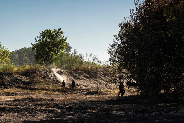 Firefighters monitor and hose down an area of scorched scrubland on the outskirts of the industrial estate at the port of Canet-en-Roussillon, the day after a wildfire broke out in the south of France, on July 3, 2026. Nearly 3,000 people had to be evacuated from several campsites, as well as from businesses and several municipalities, after a fire broke out in Sainte-Marie-la-Mer and spread on to Canet-en-Roussillon, affecting the watersports hub, firefighters and the prefect of Pyrenees-Orientales said on July 2, 2026. (Photo by Jc Milhet / AFP)