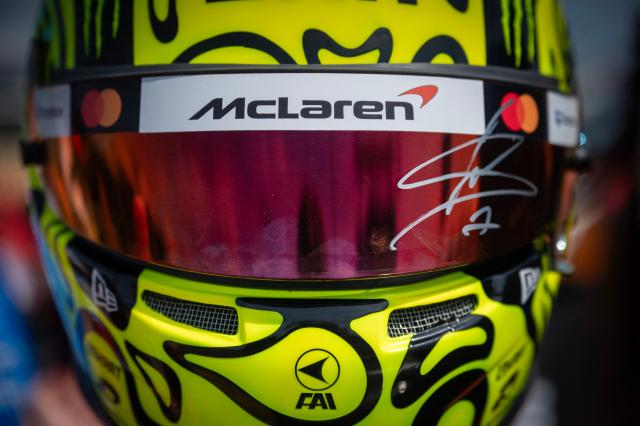 An F1 fan wears a replica helmet of McLaren's British driver Lando Norris as they wait to see drivers arrive for the first practice session ahead of the Formula One British Grand Prix at the Silverstone motor racing circuit in Silverstone, central England, on July 3, 2026. (Photo by Ben STANSALL / AFP)