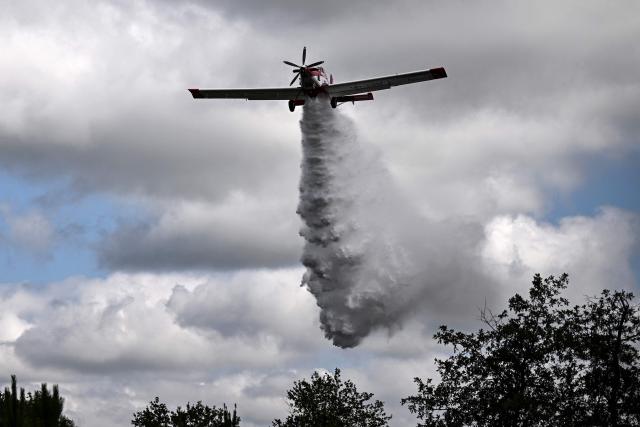 An Air Tractor AT-802 aircraft, produced by the Autralian planemaker Aerotech, drops water during a demonstration of firefighting capacity by the Gironde's Fire and Rescue Departmental Service in Saint-Aubin-de-Medoc, south-western France on July 3, 2026. Hundreds of firefighters are battling wildfires in southern France that are being fueled by wind, drought, and heat. The largest fire has been raging for two days in the Aude department, where France's Interior Minister is set to visit the disaster zone on July 3, 2026. (Photo by Christophe ARCHAMBAULT / AFP)