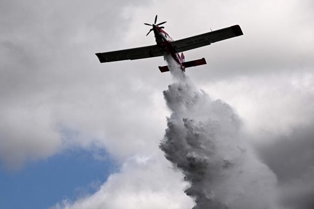 An Air Tractor AT-802 aircraft, produced by the Autralian planemaker Aerotech, drops water during a demonstration of firefighting capacity by the Gironde's Fire and Rescue Departmental Service in Saint-Aubin-de-Medoc, south-western France on July 3, 2026. Hundreds of firefighters are battling wildfires in southern France that are being fueled by wind, drought, and heat. The largest fire has been raging for two days in the Aude department, where France's Interior Minister is set to visit the disaster zone on July 3, 2026. (Photo by Christophe ARCHAMBAULT / AFP)