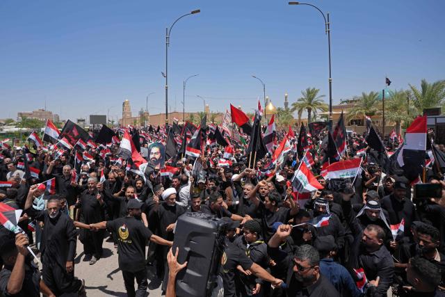 Supporters of Shia cleric Muqtada al-Sadr, wave flags as they take part in a demonstration supporting Iraqi Prime Minister Ali al-Zaidi’s government-led anti-corruption campaign, in Najaf on July 3, 2026. Iraq's new prime minister, Ali al-Zaidi, who recently took office with the blessing of the United States, has made two main vows: to fight corruption and to ensure a state monopoly on weapons. (Photo by Qassem al-KAABI / AFP)