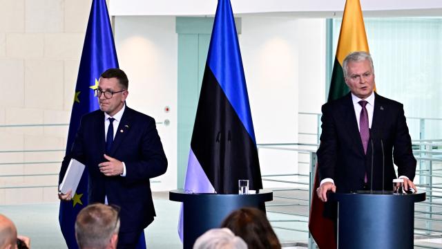 Estonian Prime Minister Kristen Michal (L) leaves while Lithuanian President Gitanas Nauseda addresses a joint press conference after a meeting with the German chancellor at the Chancellery in Berlin on July 3, 2026. (Photo by Tobias SCHWARZ / AFP)