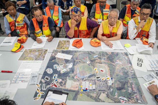 Local hunters take part in a tabletop exercise as part of an emergency response drill for bear and other wildlife intrusions, in Isehara, Kanagawa Prefecture on July 3, 2026. (Photo by Yuichi YAMAZAKI / AFP)